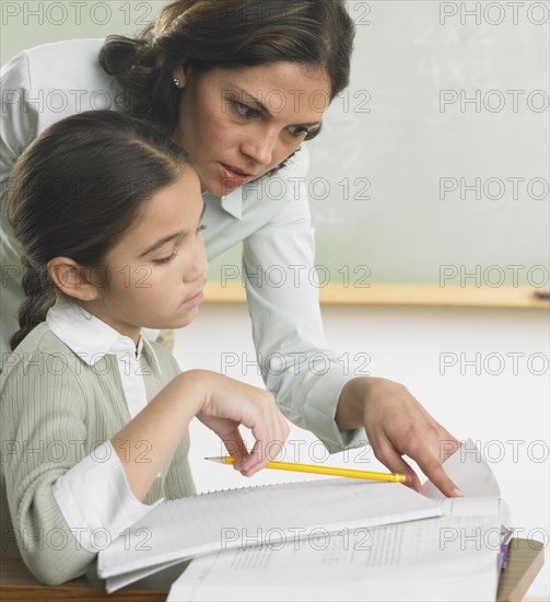 Teacher helping young student with work