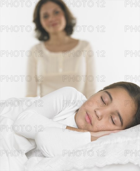 Mother watching her daughter sleep