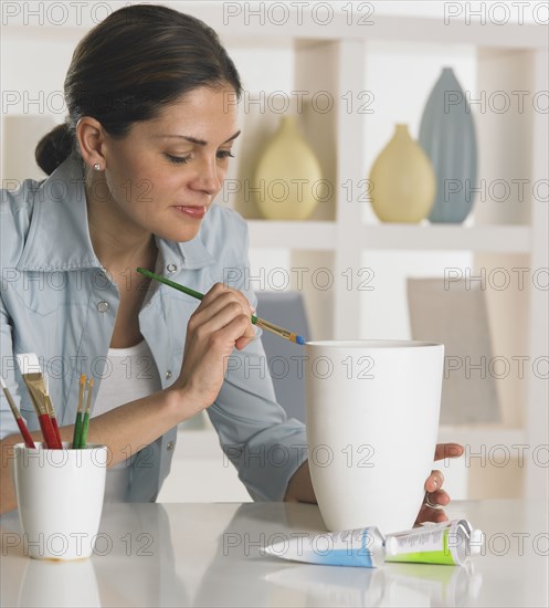 Woman painting a vase