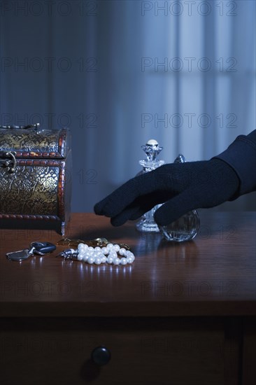 Thief reaching for a string of pearls