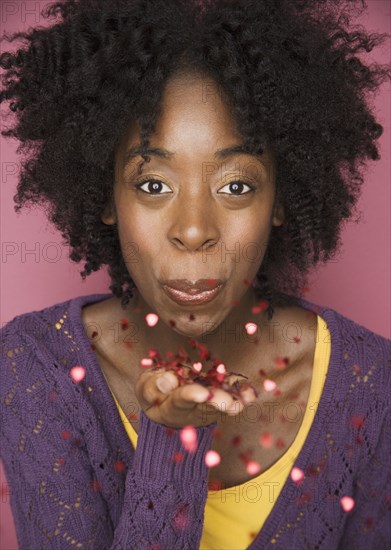 Young woman blowing confetti