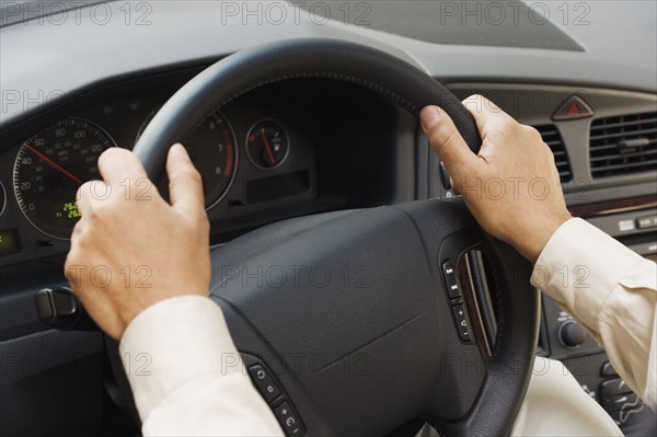 Close up of man's hands on steering wheel