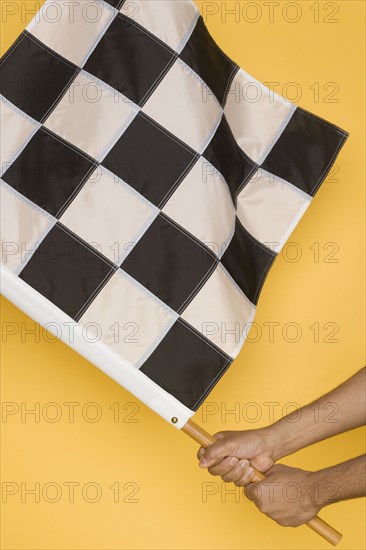 Close up of man waving checkered flag