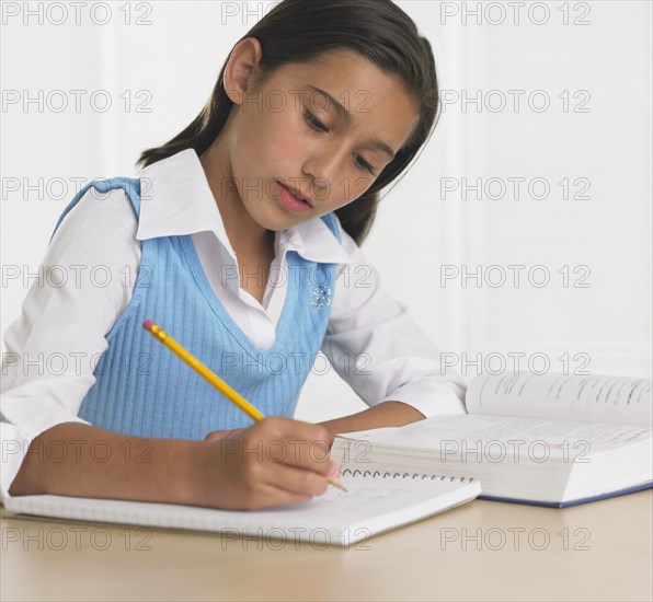 Hispanic girl doing homework at table