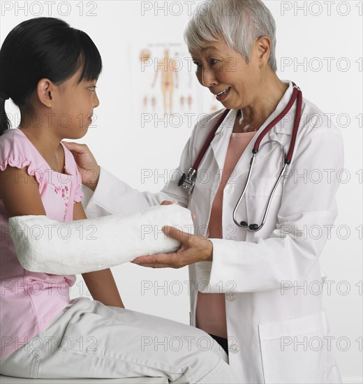 Senior Asian female doctor with young patient