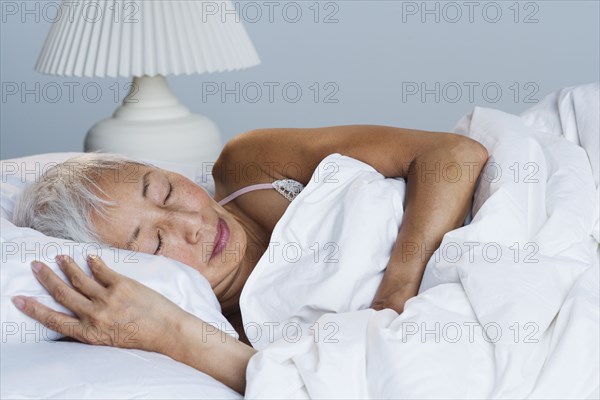 Senior Asian woman sleeping in bed