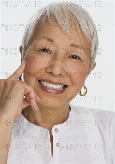 Studio shot of senior Asian woman smiling