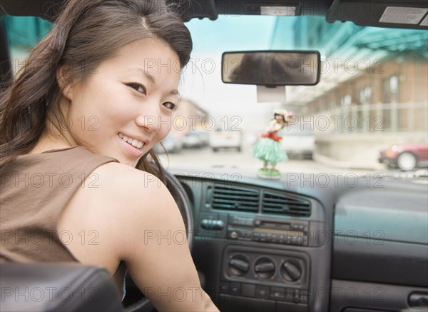 Young Asian woman driving car