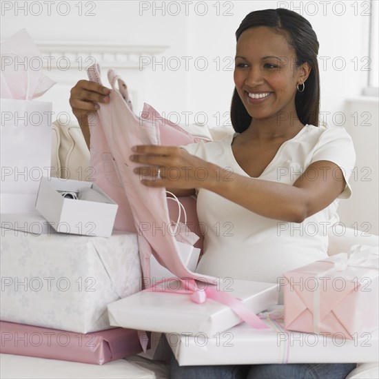 Pregnant African woman opening gifts