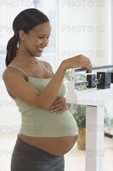 Pregnant African woman on scale