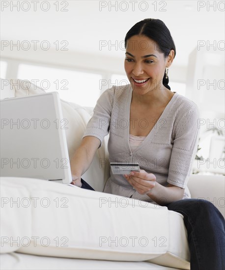 African woman shopping online on sofa