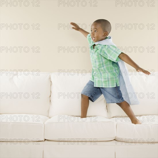 Young African boy playing on sofa