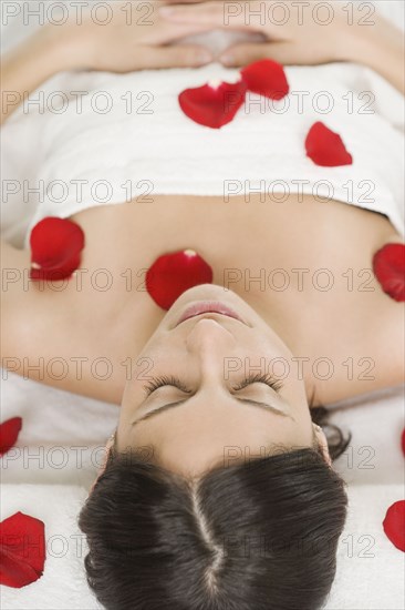 Hispanic woman covered in flower petals