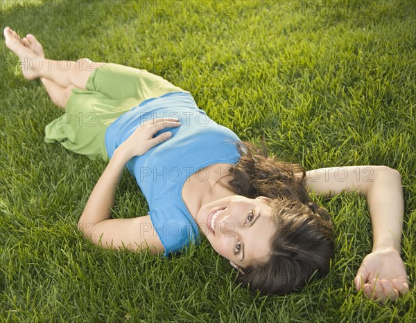 Hispanic woman laying in grass