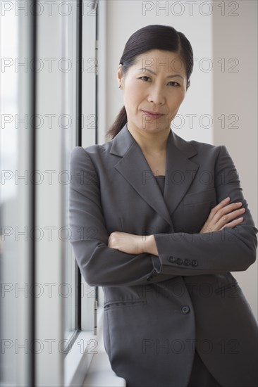 Middle-aged Asian businesswoman with arms crossed