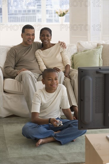 African family watching television in livingroom