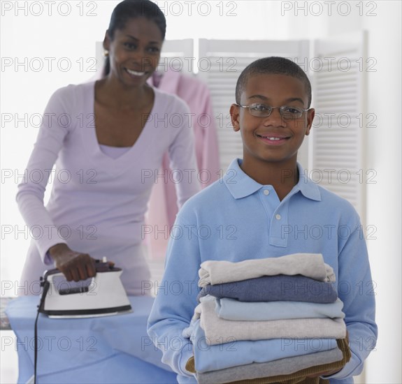 African boy helping mother with laundry