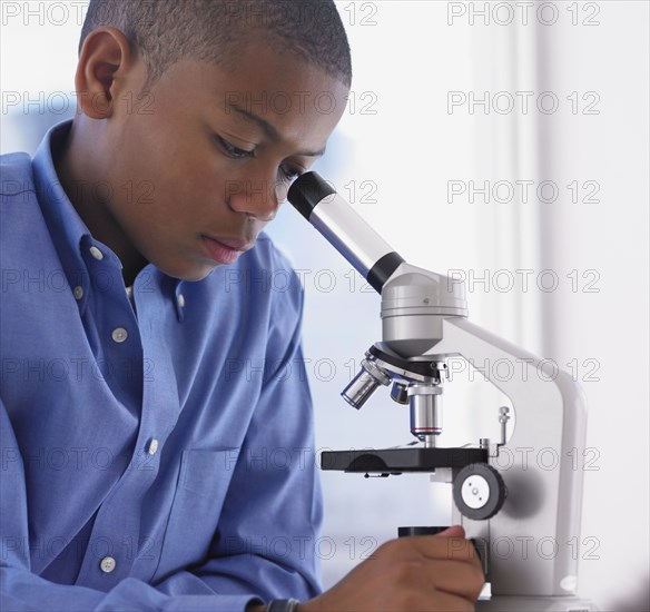African boy looking into microscope