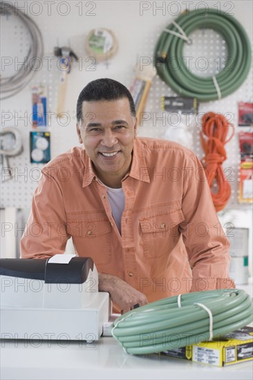 African hardware store owner smiling behind counter