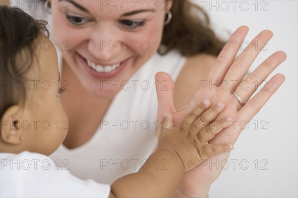 Hispanic mother and baby clapping hands