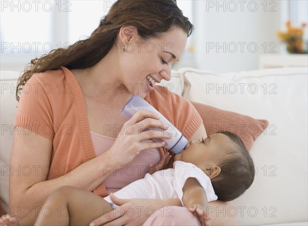 Hispanic mother bottle feeding baby