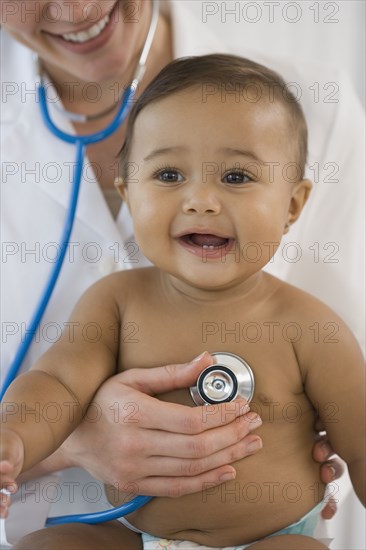 Hispanic baby being examined by doctor