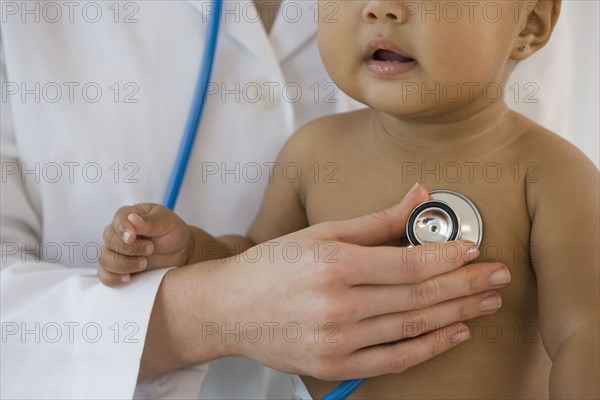 Hispanic baby being examined by doctor