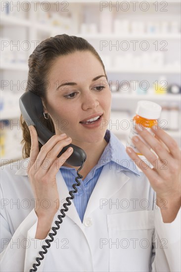 Hispanic female pharmacist talking on telephone