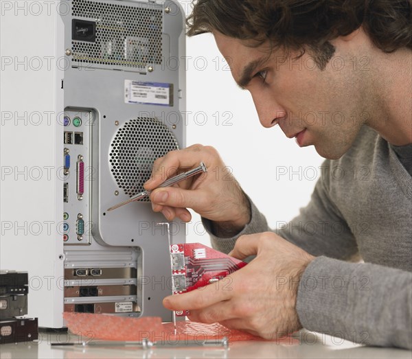 Hispanic man fixing computer