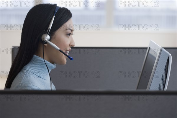 Asian businesswoman working in cubicle