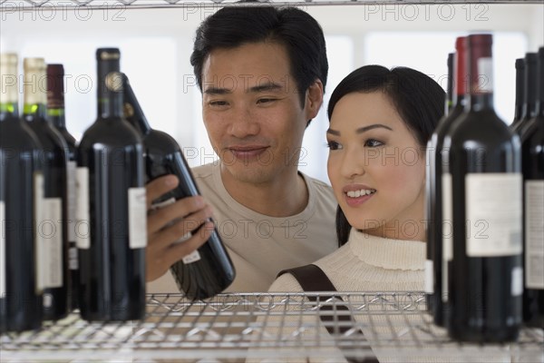 Asian couple selecting wine