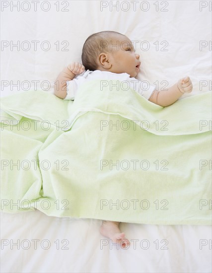 High angle view of newborn baby under blanket