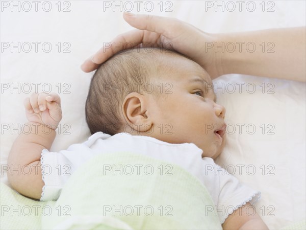 Close up of mother touching newborn baby's head