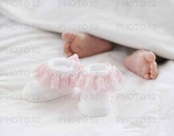 Baby booties next to newborn baby's feet