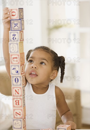 African girl building tower of blocks