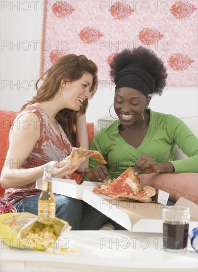 Two women eating pizza