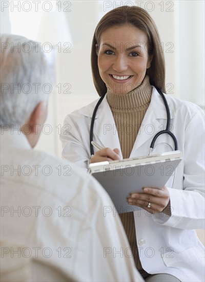 Portrait of Hispanic female doctor writing on chart