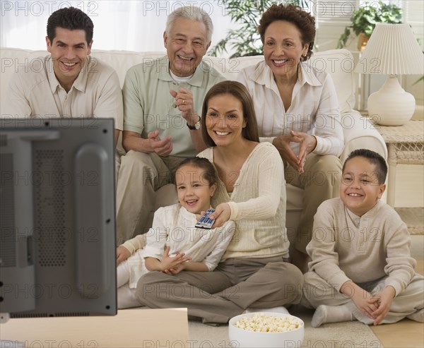 Multi-generational Hispanic family watching television