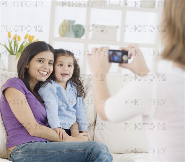 Hispanic mother and daughter having photograph taken