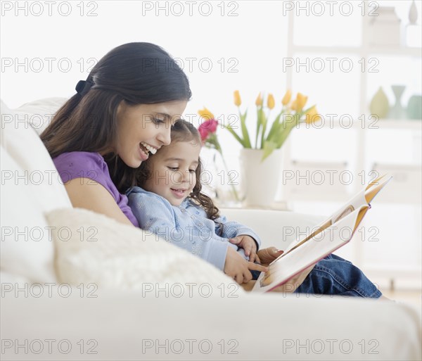 Hispanic mother reading to daughter