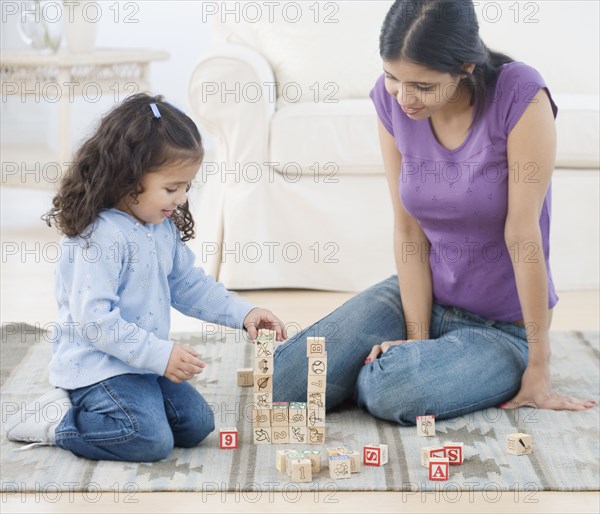 Hispanic mother and daughter playing with blocks