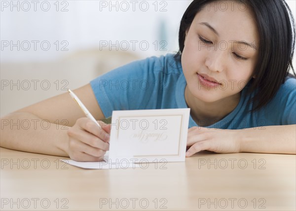 Asian woman writing Thank You card