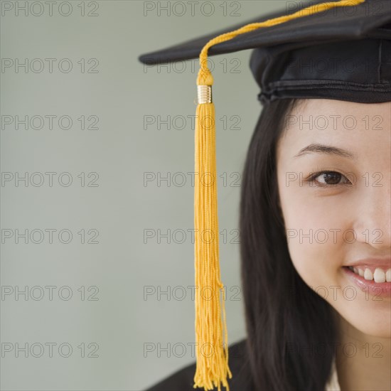 Asian woman wearing graduation cap