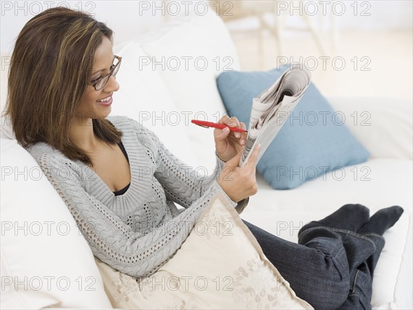 Indian woman reading newspaper classifieds