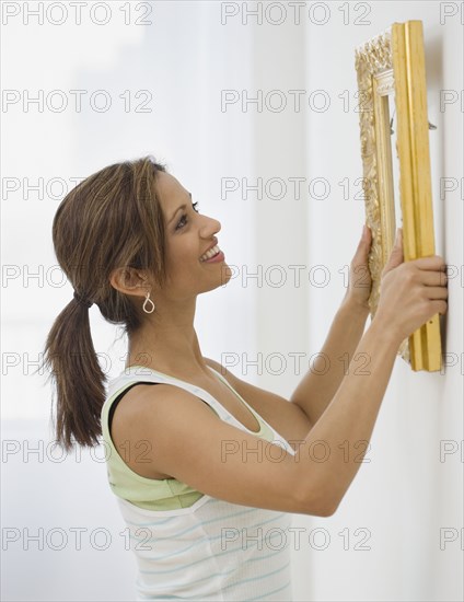 Indian woman hanging picture