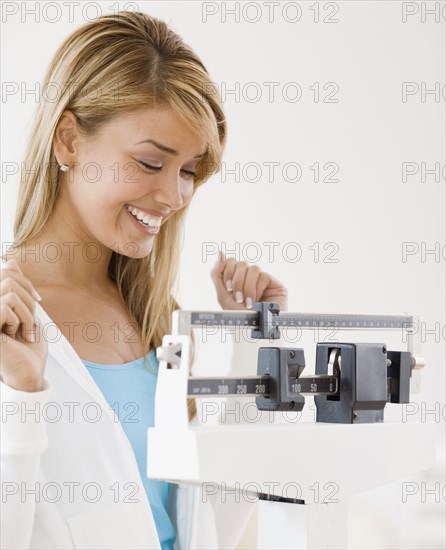 Hispanic woman weighing self