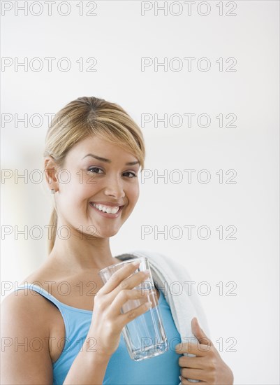 Hispanic woman drinking glass of water