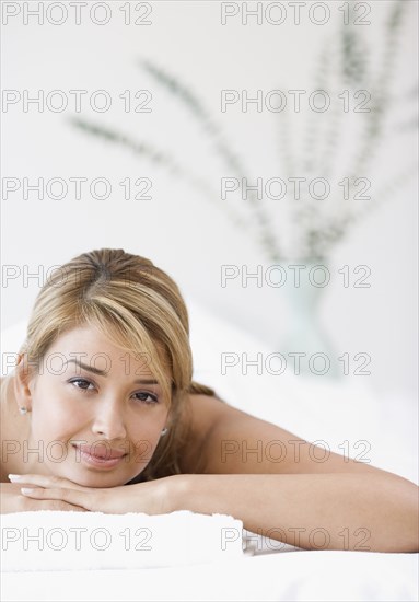 Hispanic woman laying on spa table