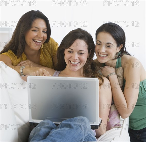 Three young women looking at laptop