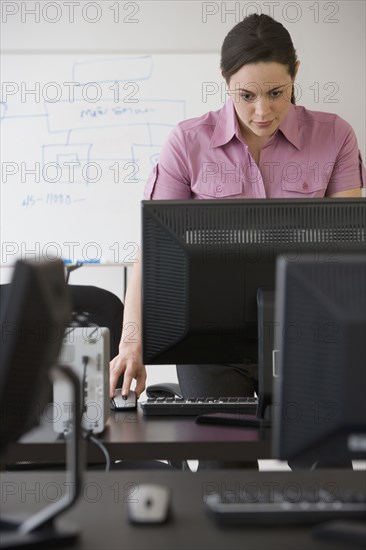 Hispanic businesswoman looking at computer